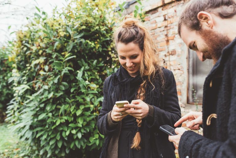 couple-in-garden-looking-at-smartphones-2022-03-04-01-53-27-utc